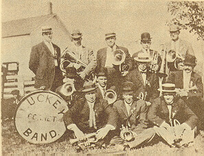 Band members pose for the photo in two rows, with the front row sitting down next to a drumhead labelled Luckey Cornet Band.