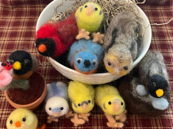 multiple birds made by needle felting, including a cardnial.