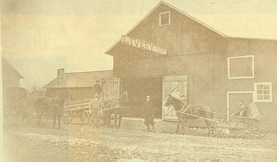 Men bring their horses and carts to a livery stable.