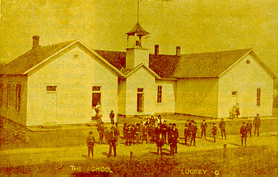 Figures congregate before the schoolbuilding.