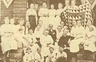 Members of the quilting circle pose with one of their quilts on the steps of the church.