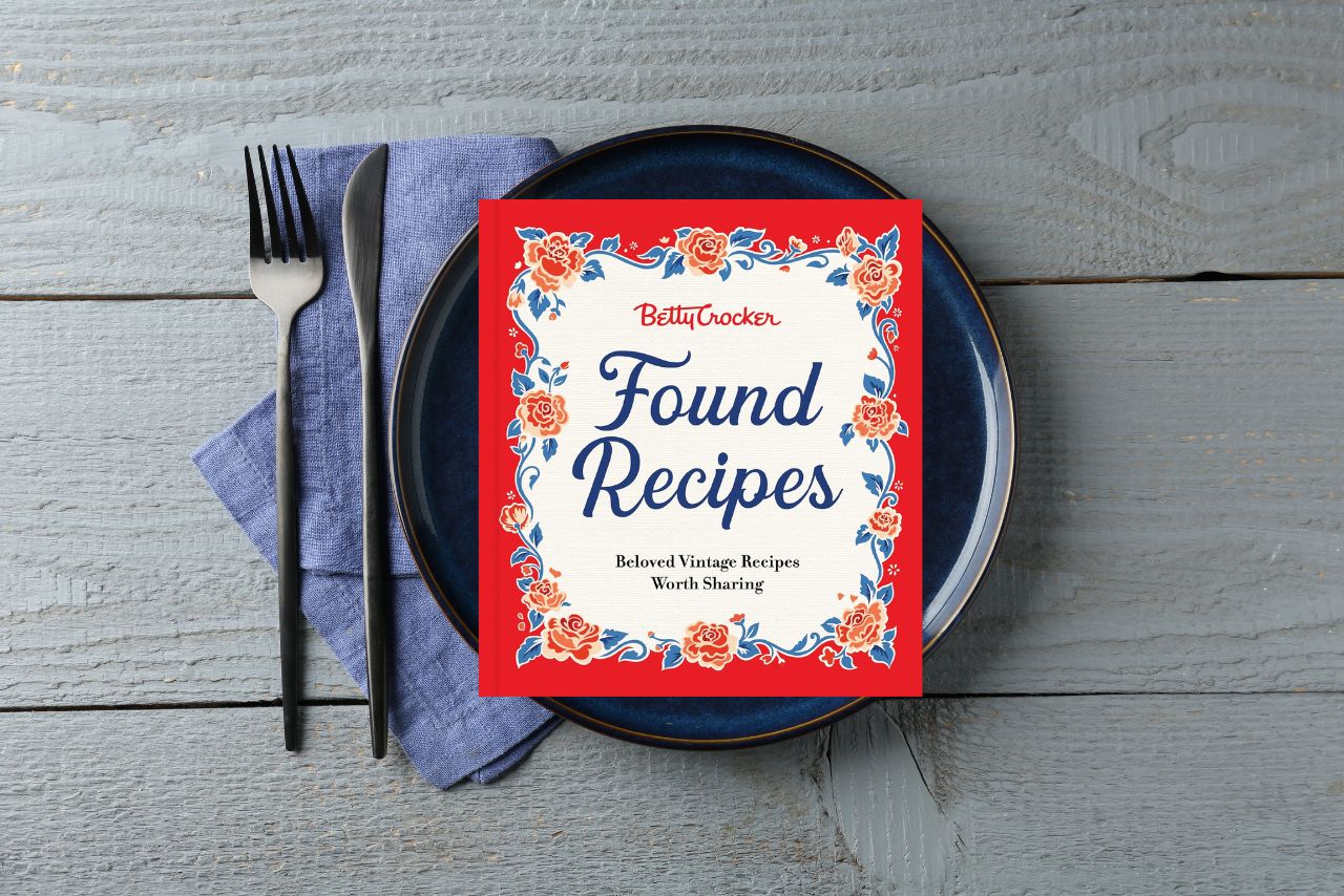 This month's cookbook set out on a blue plate, with a blue napkin and silverware to the side.