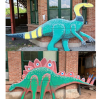 Two different dinosaur murals positioned in front of a brick building.