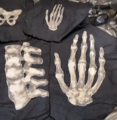 Bone shapes bleached onto dark fabric.