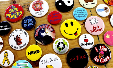 An assortment of pins laid out on a wooden surface.