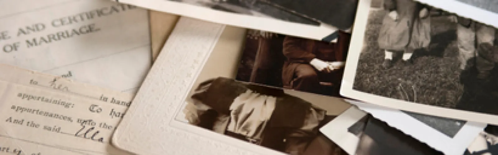 old photographs and letters sit on top of a table